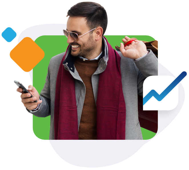 Man holding shopping bags while looking at his phone